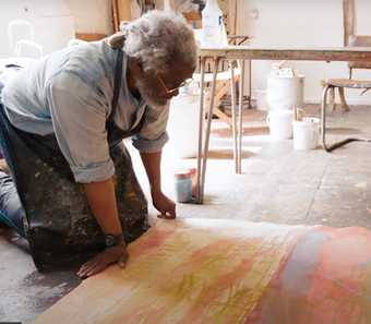 two people draw on painting on the floor