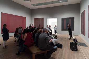 a woman stands in front of a Rothko painting