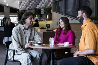 Three people socialising with cake and coffee